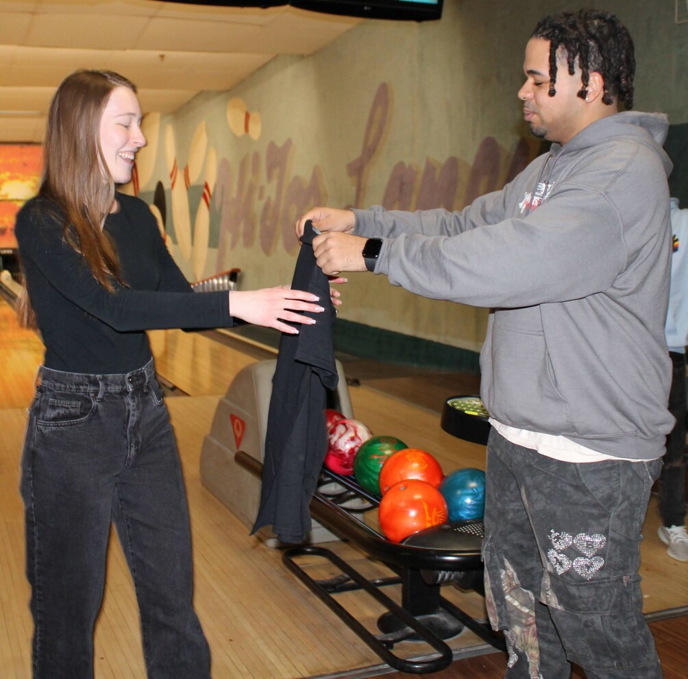 Manuel Santana giving out a free NYIAN shirt to local resident, Laura Augliera